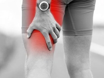 A person holding their thigh, indicating potential discomfort or pain.