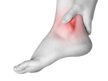 A person holding their ankle, expressing discomfort or pain.