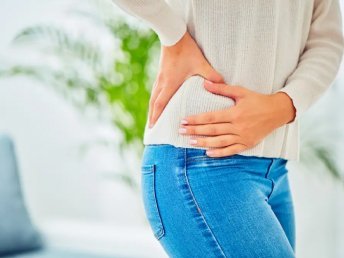 A person holding their hip, signaling potential discomfort or pain.