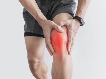 Individual holding their knee, expressing discomfort or pain.