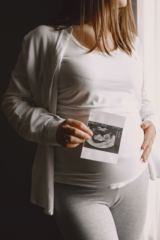 Aesthetically presented pregnancy scan results as a glowing expectant mother joyfully reveals the details of her upcoming journey into parenthood.